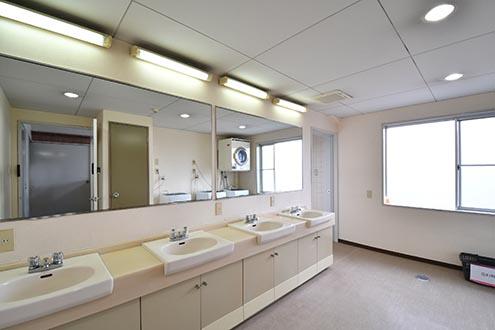水まわり設備の様子。水まわり設備は全フロア2室ずつ用意されています。洗面台が3台並んでいます。洗面台の対面に洗濯機が設置されています。（A棟）|4F 洗面台