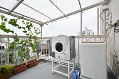 ルーフバルコニーに設置された乾燥機と洗濯機の様子。屋根付きです。(2021-07-09,共用部,LAUNDRY,5F)