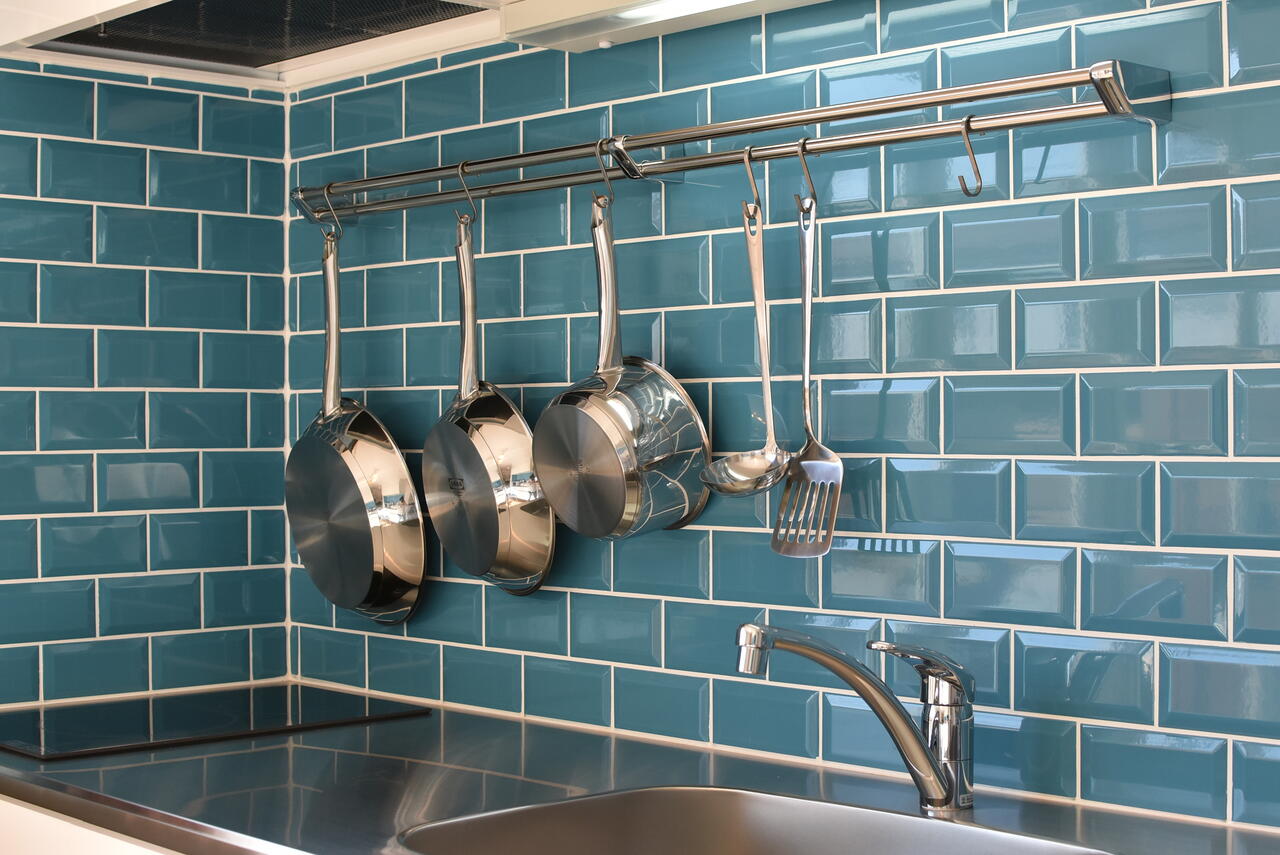 キッチンの壁に共用の鍋やフライパンが掛けられています。|1F キッチン