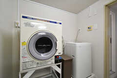 洗濯機と乾燥機の様子。奥にトイレがあります。(2021-03-11,共用部,LAUNDRY,1F)