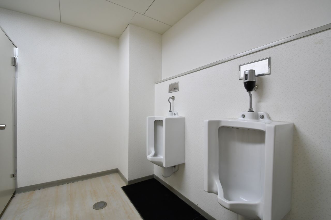 男性用立ち式トイレの様子。対面に洋式トイレが2箇所設置されています。（A棟）|1F トイレ