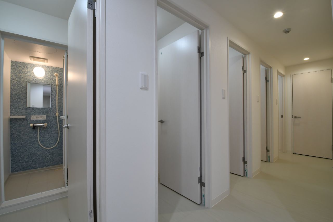 シャワールームの様子。左手から男性専用シャワールームが2室、男女共用シャワールーム、女性専用シャワールームが2室です。（A棟）|-1F 浴室