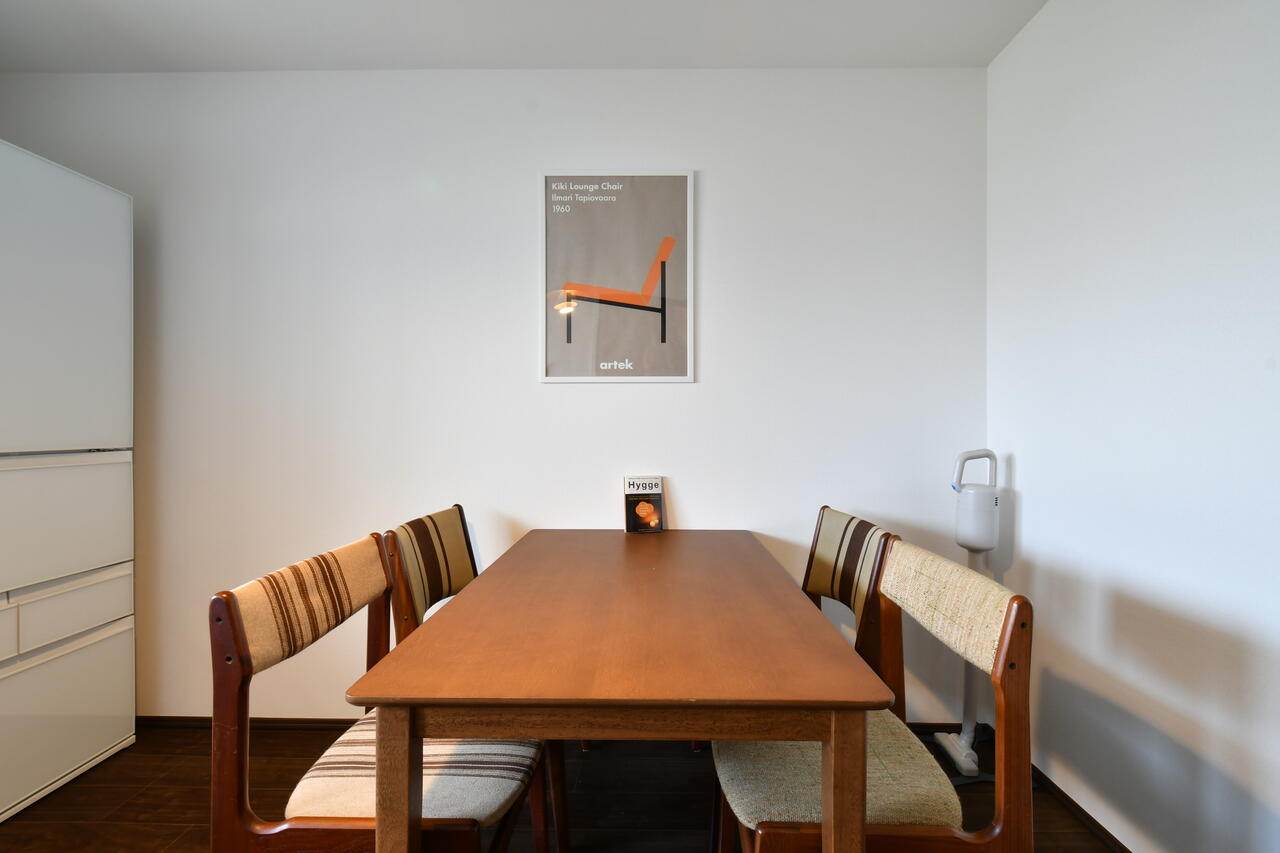 ダイニングテーブルの様子。壁には絵画が飾られています。（A棟）|1F リビング
