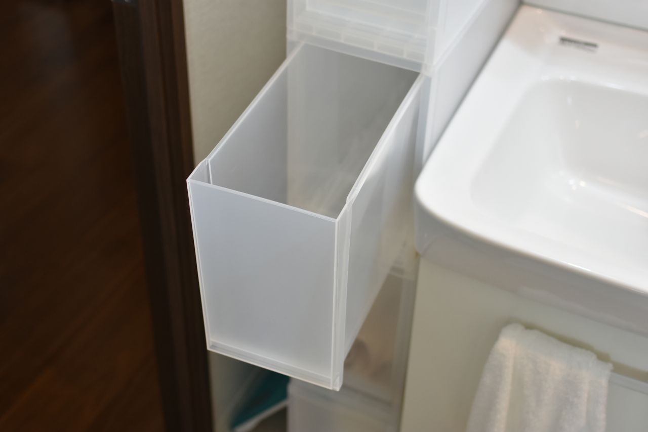 洗面台脇には収納棚が設置されていて、専有部ごとに使えるスペースが決まっています。（A棟）|1F ランドリー