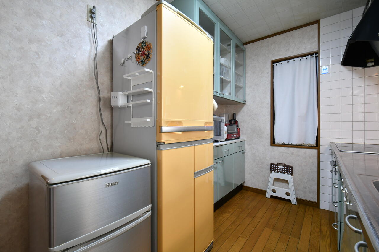 シンクの対面には、冷蔵庫と食器棚が設置されています。シルバーの冷蔵庫には、ケーキ屋で使用する材料類が保管されています。|2F キッチン
