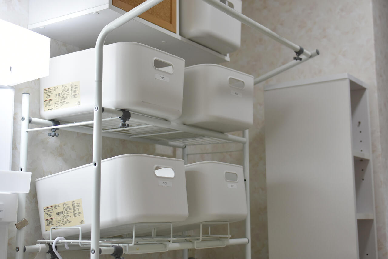 洗濯機上に設置された収納の様子。専有部ごとに使えるスペースが決まっています。|2F ランドリー