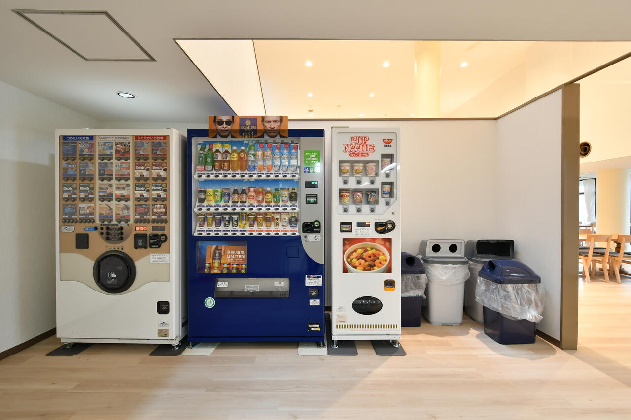 キッチンの隣に自動販売機が並んでいます。軽食も購入可能。|1F キッチン