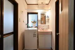脱衣室の様子。左がバスルーム、右がトイレです。洗面台と洗濯機が設置されています。(2022-08-05,共用部,BATH,1F)