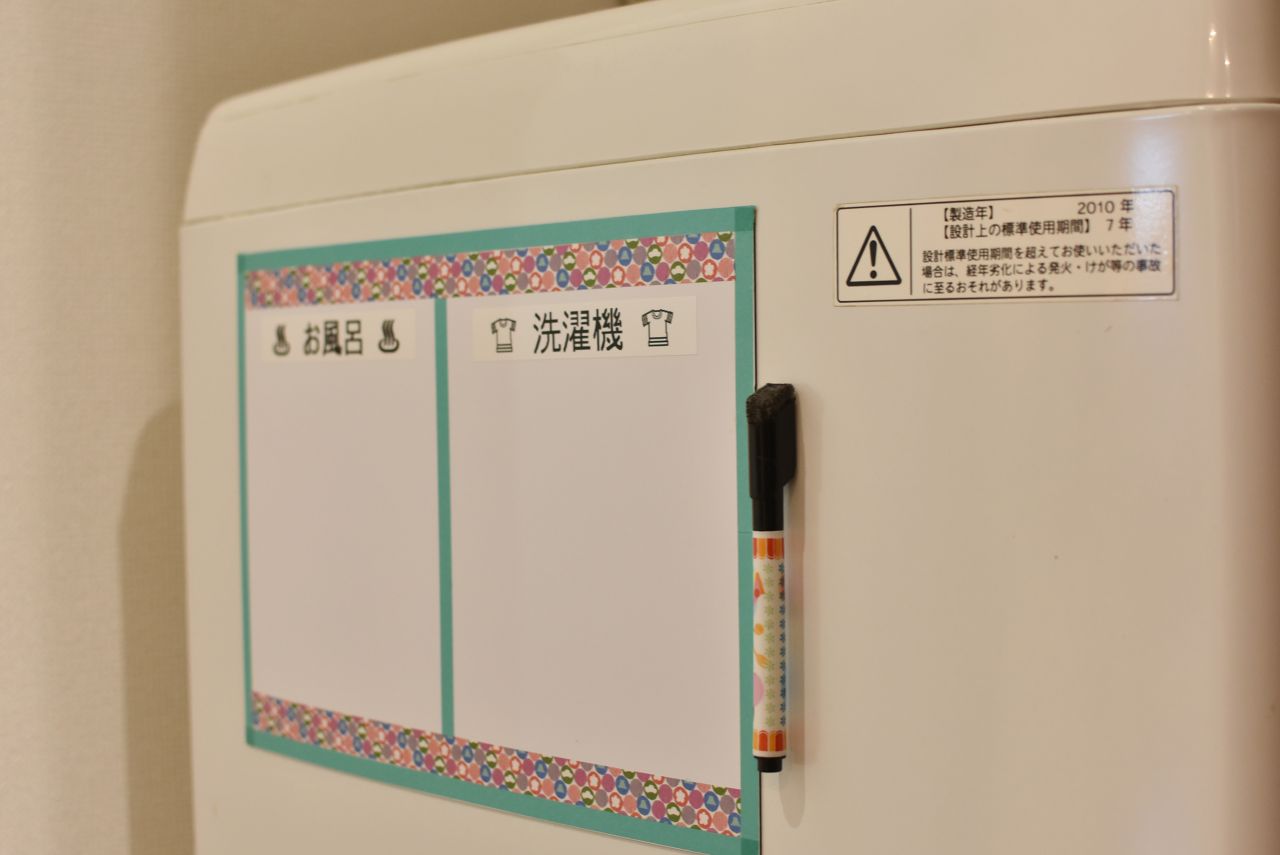 洗濯機にはホワイトボードが貼られています。予約して使用する場合は記入をするとのこと。(2018-03-08,共用部,LAUNDRY,1F)