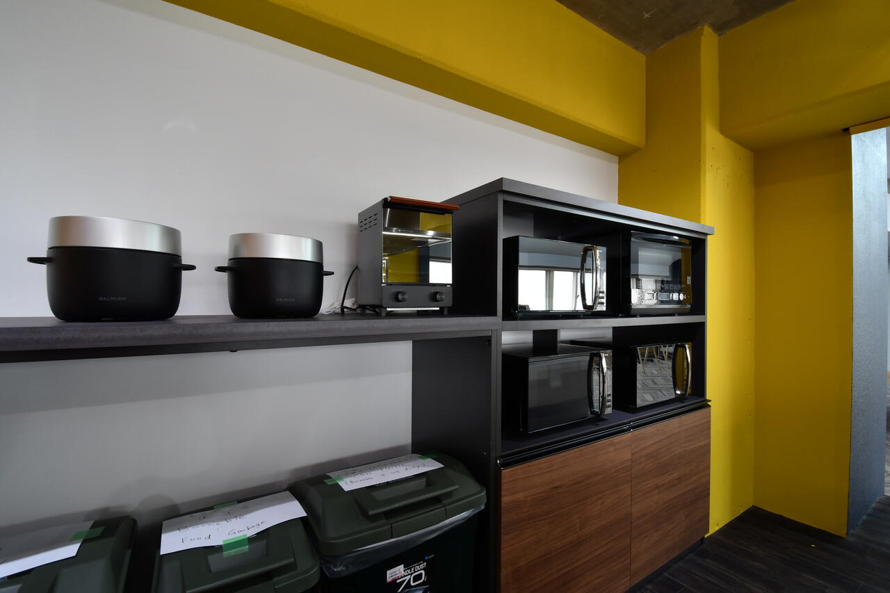 収納棚の上にはオーブントースターや電子レンジが置かれています。炊飯器はバルミューダ社の「BALMUDA The Gohan」です。|2F キッチン