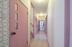 廊下の様子。突き当りがリビングです。ドア周りはピンク色で塗られています。左手が水周り設備が並び、右手が専有部です。(2012-11-16,共用部,OTHER,1F)