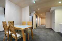 テーブルの先にある廊下には専有部が並び、その突き当りの右手に水回り設備があります。(2013-01-25,共用部,LIVINGROOM,1F)