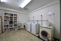 ランドリールームの様子。洗濯機が2台、乾燥機が1台設置されています。奥に本棚が設置されています。(2017-10-31,共用部,LAUNDRY,3F)