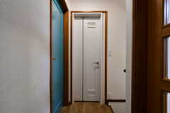 廊下の様子。正面の白いドアがバスルーム、左の水色のドアが201号室、背面にトイレがあります。(2022-03-22,共用部,OTHER,2F)