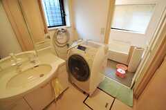 脱衣室に設置された洗面台とドラム岸洗濯機の様子。洗濯機はサイズの関係で写真のような設置位置となっています。(2012-09-12,共用部,BATH,1F)