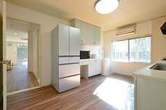 キッチンの対面には食器棚と冷蔵庫、奥に洗濯機が設置されています。(2014-12-08,共用部,KITCHEN,2F)