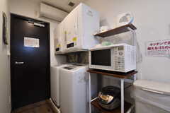 左手から乾燥機と洗濯機が各2台と収納棚が設置されています。収納棚には電子レンジが置かれています。(2018-09-07,共用部,KITCHEN,1F)