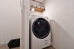 ドラム式洗濯機の様子。洗濯機の上に棚が設置されています。棚には部屋ごとに収納ボックスが用意されています。(2019-04-16,共用部,LAUNDRY,2F)